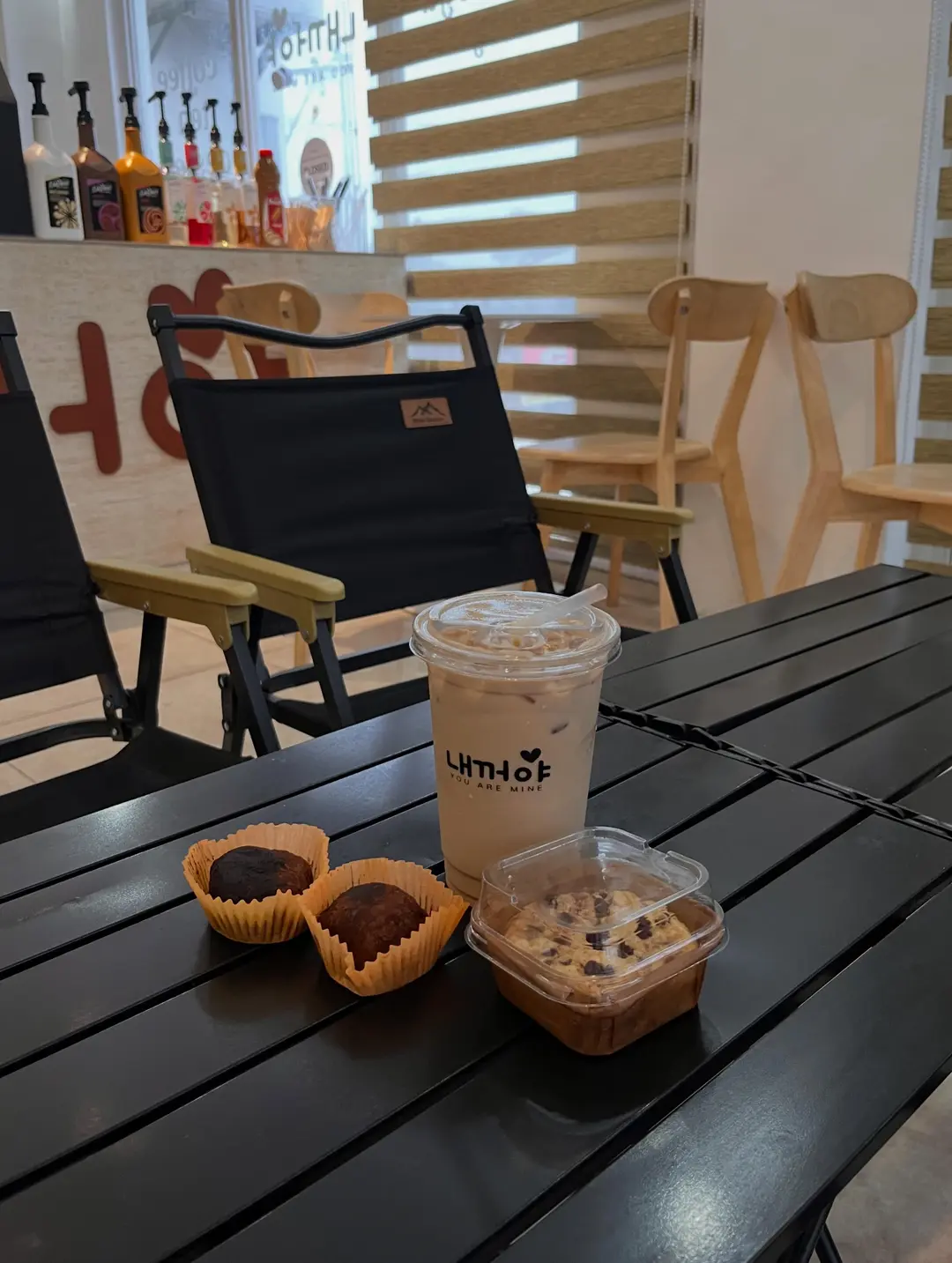 Camp chair with an iced drink and a snack basket on the dark terrace table