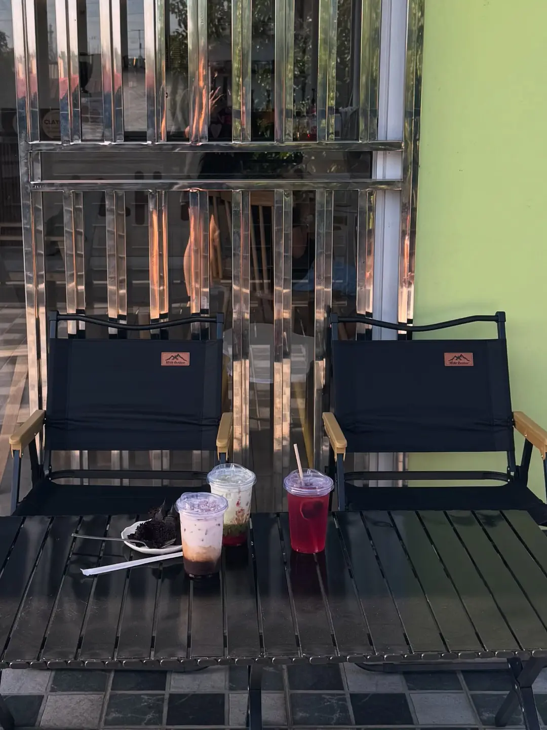Al fresco camp chairs and colorful drinks on the checkered terrace at golden hour